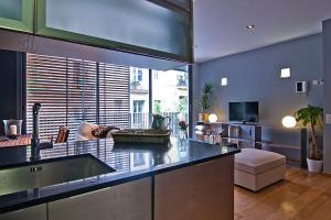 a kitchen with a sink and a living room at Apartment Barcelona Rentals - Gracia Pool Apartments Center in Barcelona
