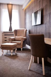 sala de estar con 2 sillas, silla y sofá en Hotel Ideja, en Banja Luka