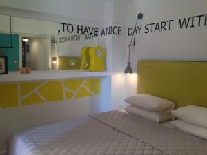 a bedroom with a bed with a yellow headboard and a mirror at The Orange Apartments in Thessaloniki