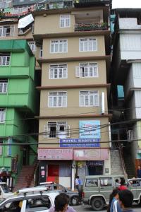 een hoog gebouw met auto's geparkeerd voor het bij Hotel Kasturi in Gangtok