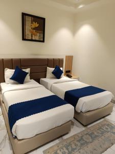 a bedroom with two beds with blue pillows at Rudram Inn in Varanasi