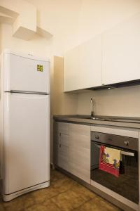 a kitchen with a white refrigerator and a stove at Casa Vacanza La Fornace Matera centro in Matera