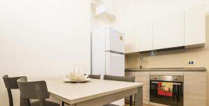 a kitchen with a table with chairs and a refrigerator at Casa Vacanza La Fornace Matera centro in Matera