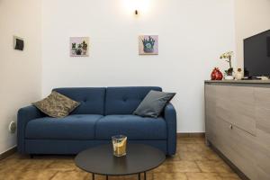 a living room with a blue couch and a table at Casa Vacanza La Fornace Matera centro in Matera