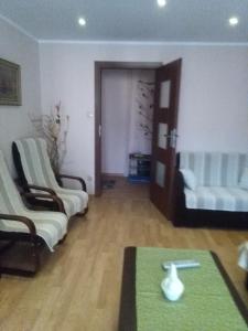 een woonkamer met 2 stoelen en een tafel bij Apartament Kasprusie 65m2 in Zakopane
