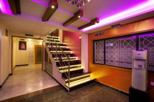 un escalier dans un bâtiment aux lumières violettes dans l'établissement Hotel Lotus, à Madurai