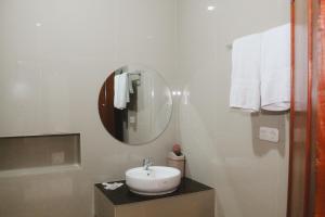 a white bathroom with a sink and a mirror at Hotel Indria in Bukittinggi +57 photos