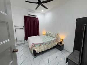 a bedroom with a bed and a ceiling fan at Student Homestay in Kampong Ru Sepuloh