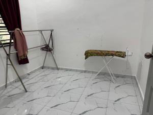 a room with a chair on a tiled floor at Student Homestay in Kampong Ru Sepuloh