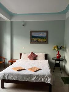 a bedroom with a bed with two towels on it at Sunshine Loop Hostel in Làng Lap