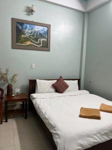 a bedroom with two beds and a picture on the wall at Sunshine Loop Hostel in Làng Lap +5 photos