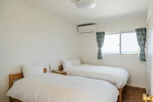 two beds in a room with a window at Villala Fibana in Motobu +76 photos