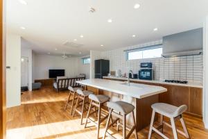 a kitchen with a large island with bar stools at Villala Fibana in Motobu