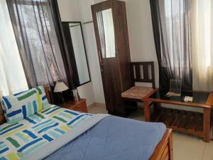 a bedroom with a bed and a chair and a mirror at Hill View Homes,AC Suites in trivandrum in Trivandrum