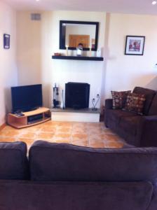 a living room with a couch and a tv at Glendale Chestnut Grove in Rosslare