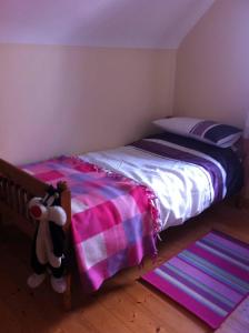 een slaapkamer met een bed met een roze en paarse deken bij Glendale Chestnut Grove in Rosslare