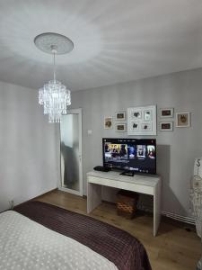 a bedroom with a bed and a television and a chandelier at Relax Apartament in Constanţa