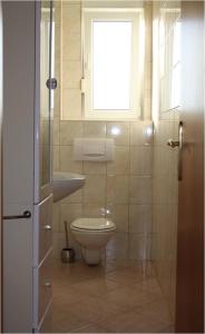 a bathroom with a toilet and a sink and a window at Apartment Put Draga in Kožino