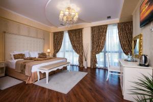 a bedroom with a large bed and a chandelier at Hotel De Paris in Krasnodar
