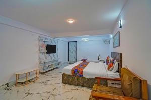 a bedroom with a king sized bed and a tv at FabHotel Shree Ji in Lucknow