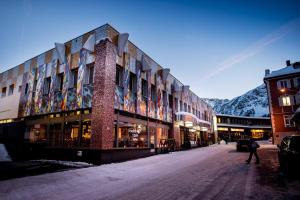 eine Person, die vor einem Gebäude eine Straße hinuntergeht in der Unterkunft Kursaal Arosa in Arosa