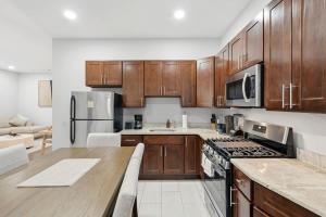 a kitchen with wooden cabinets and a stove top oven at Spacious 3BR 2BA Apt with Private Parking Walk to PATH in Jersey City