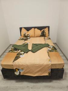 a bed with a blanket and pillows on it at La Sibip in Târgu Neamț