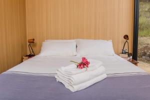ein Bett mit Handtüchern und einer Blume darauf in der Unterkunft Greenmount by Tiny Away in Greenmount