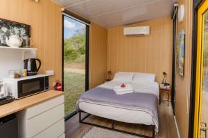 ein kleines Schlafzimmer mit einem Bett in einem Wohnwagen in der Unterkunft Greenmount by Tiny Away in Greenmount