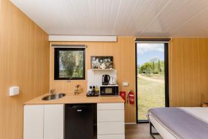 eine Küche mit Spüle und ein Bett in einem Zimmer in der Unterkunft Greenmount by Tiny Away in Greenmount