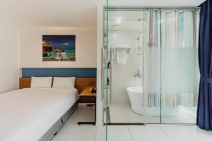 a bedroom with a bed and a shower and a tub at Hamdeok Beach Stay Jeju in Jeju +80 photos
