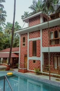 a house with a swimming pool in front of a building at The Chira House in Alībāg