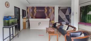 a living room with two chairs and a table at Hotel Sri Indrawati Puncak Mitra RedDoorz in Bogor +18 photos