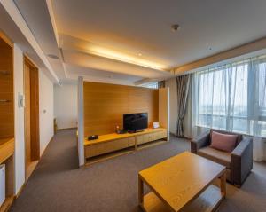 a living room with a tv and a couch and a table at Best Western Hotel Gunsan in Gunsan-si
