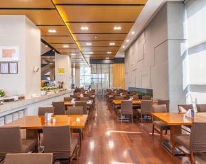 a dining room with wooden tables and chairs at Best Western Hotel Gunsan in Gunsan-si