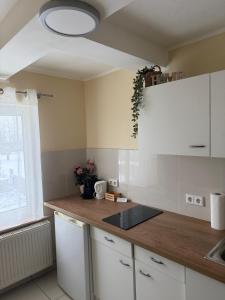 a kitchen with white cabinets and a wooden counter top at Gemütliches Appartement 5 - mit Küche und Bad zur Eigennutzung -Schuster Homes- in Vechelde