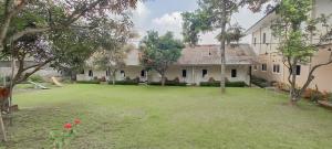 anterior view of a house with a large yard at Hotel Sri Indrawati Puncak Mitra RedDoorz in Bogor