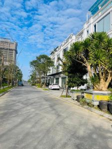 an empty street in a city with trees and buildings at Sò homestay in Thôn Văn Dương