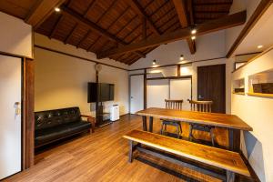 a living room with a wooden table and a couch at こんぴら町家 Konpira Machiya in Kotohira