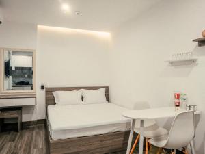 a small room with a bed and a table at sentosa apartments in Dien Ban