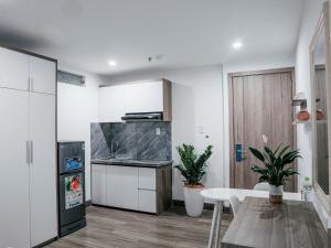 a kitchen with white cabinets and a table in it at sentosa apartments in Dien Ban