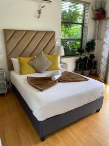a bedroom with a large white bed with yellow pillows at The View on Nyle Rustenburg in Rustenburg +57 photos