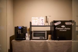 a table with a microwave and other items on it at Kyohotel Kishotei Goshominami in Kyoto