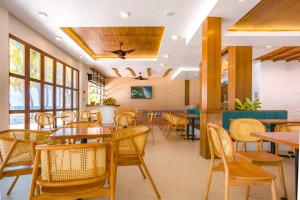 a restaurant with tables and chairs and windows at Thundi by Biosphere in Maalhos