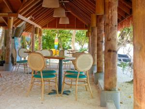 a table and chairs in a pavilion with a table at Thundi by Biosphere in Maalhos