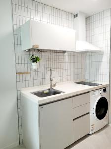 a white kitchen with a sink and a dishwasher at 슈기스테이 in Seoul