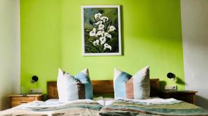 a bedroom with green walls and a bed with pillows at Weingut Herrenhof Andrea Thielen in Minheim