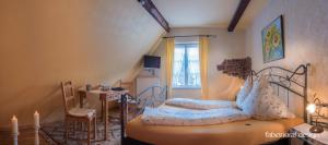 a bedroom with a bed and a table and a window at Weingut Herrenhof Andrea Thielen in Minheim