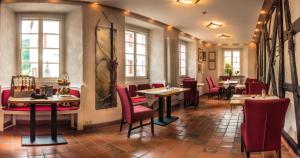 a restaurant with tables and chairs and windows at Weingut Herrenhof Andrea Thielen in Minheim