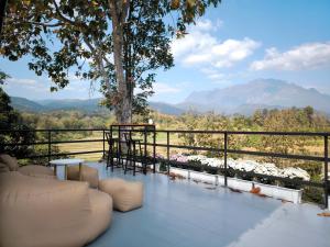 a balcony with a view of a tree and mountains at De Napa - Private Homestay in Ban Mae Na